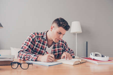 Confident smart concentrated student writing home taskの写真素材