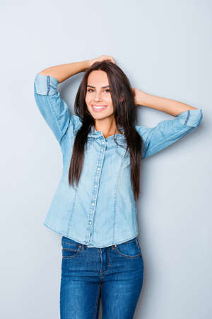 Pretty woman with beaming smile touching her hairの写真素材