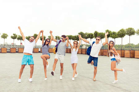 joyful happy young people having fun and  walking square of cityの写真素材