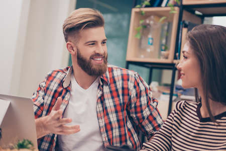 Young man and woman having conversation during business seminarの写真素材