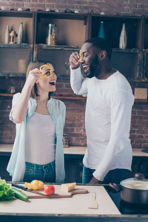 handsome afro american guy with his beautiful caucasian girl in kitchen having funの写真素材