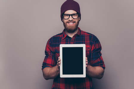 Happy young hipster man showing blank tablet screenの写真素材