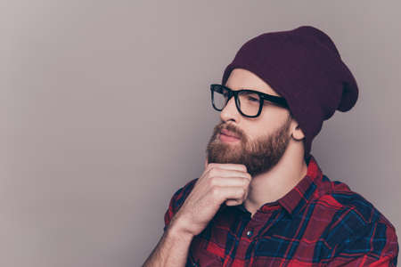 Young handsome thoughtful bearded man in hat and glassesの写真素材