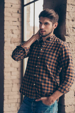 Portrait of young stylish man holding hand in pocket of jeansの写真素材