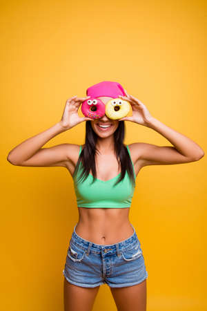 Comic slim hipster woman making glasses with two donutesの写真素材