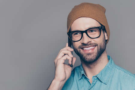 Portrait of young smiling hipster man talking on mobile phone
