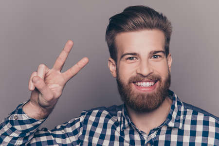 Young happy cheerful man showing two fingersの写真素材