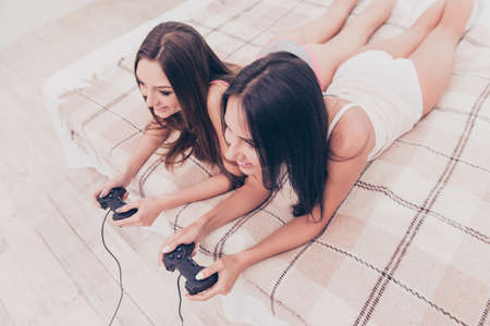 Pretty happy best friends having fun and playing video gameの写真素材