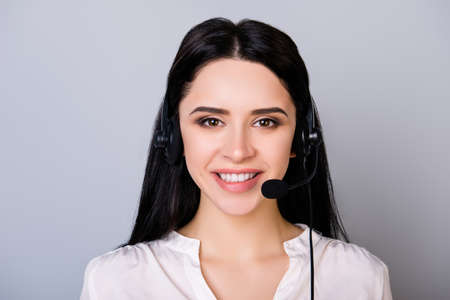 Portrait of young consultant of call center in headphones isolated on gray backgroundの写真素材