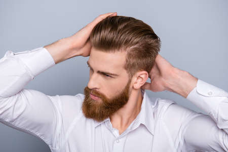 Portrait of confident man with red beard touching his hairの写真素材