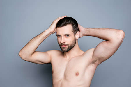 A portrait of a young handsome naked man touching his hair after taking a showerの写真素材