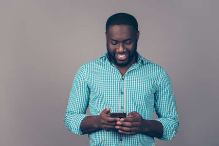 Portrait of happy afroamerican  bearded  man using smartphone and read sms