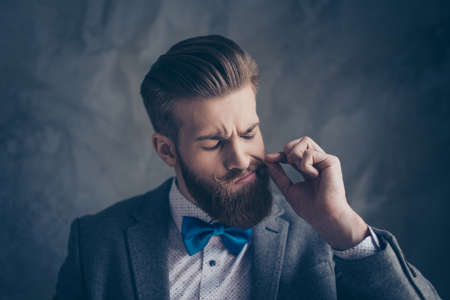Portrait of stylish hipster young man with beard and beautiful hairstyle ready for event party and...