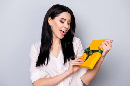 Portrait of pretty young  laughing woman holding present because of her birthdayの写真素材