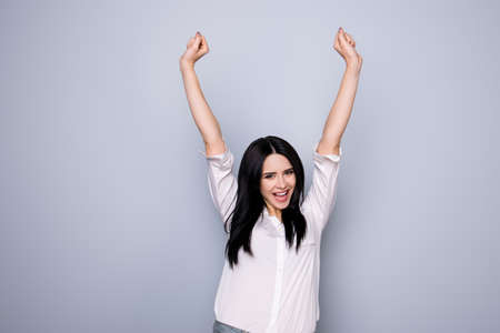 yeah portrait of happy cute young  woman with toothy smile raised hands and celebrate victory