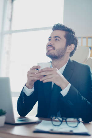 Vertical photo of young smiling handsome  entrepreneur in black and white formal-wear with tie...
