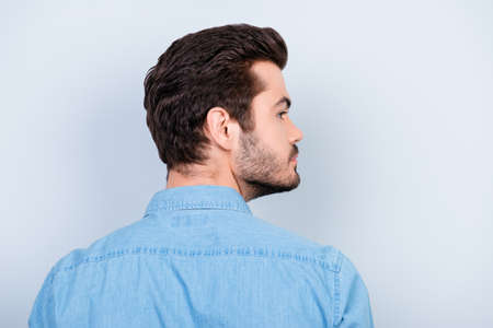 Back view of stylish young brunet man with modern hairstyle on light blue backgroundの写真素材