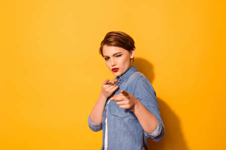 you got it playful attractive young girl is pointing on the camera with fingers. she is wearing casual closes, red pomadeの写真素材