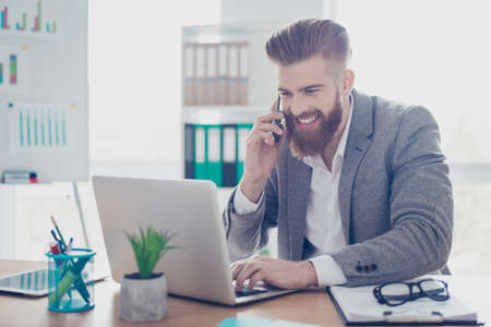 Cheerful businessman is smiling talking to businesspartner about success of the company. Income...