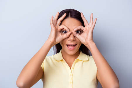 Close up portrait of a playful young latin girl. She is in casual closes, showing the glasses with...