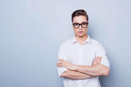 Close up portrait of handsome young man in white shirt  and glasses, standing on the pure light...