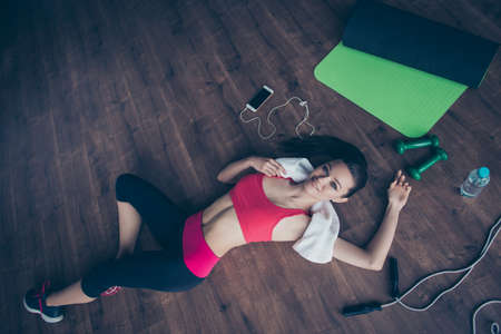 Young pretty  sporty girl relaxing after gym exercises of cross fitの写真素材