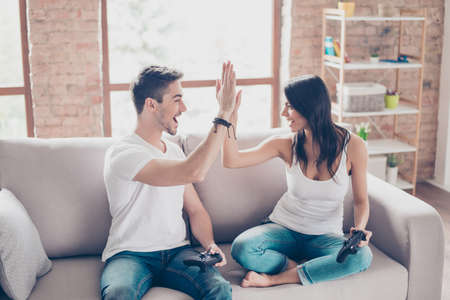 Did it! The best team ever. Beautiful hispanic lovers on a date indoors, they are playing video...