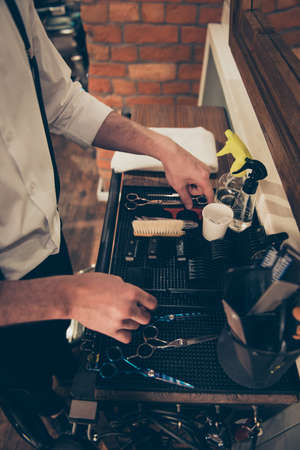 Close up cropped photo of accessories of a barber shop stylist. He is organizing them in the order  at his work placeの写真素材