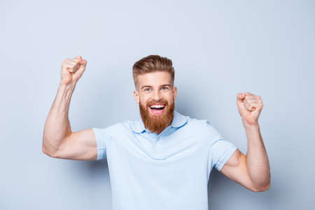 Great job! Very excited young red bearded stylish freelancer is celebrating the growth of conmpany`s...