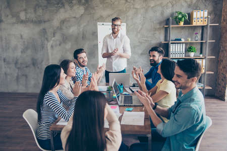 Successful business team is clapping their hands in modern workstation, celebrating the performance...