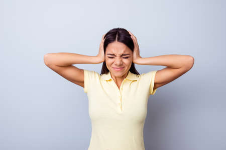 Stop it! Young mulatto girl is covering her ears because of noises, she is stressed and tired