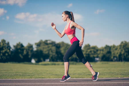 Young athlete trainer is preparing for marathon. Beautiful fitness model, in fashionable sports...