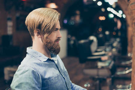 Profile portrait of harsh stylish red bearded man in a barber shop.の写真素材