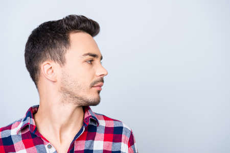 Profile side photo of young hipster brunet guy, standing in casual outfit on pure blue background...