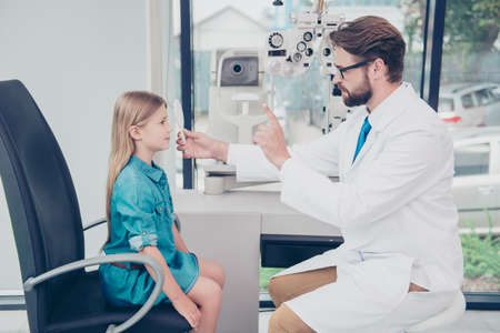Health care, medicine, eye sight and technology concept. Side profile of brunet bearded optometrist...