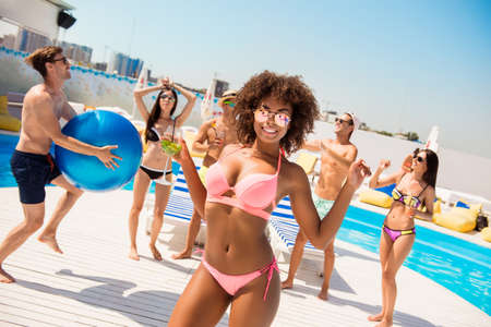 Hot mulatto chic with mohito is posing, dancing at the beach pool disco party, enjoying, chilling...