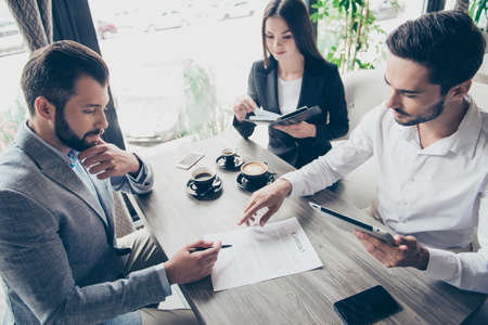 Young business partners are making a deal with lawyer about their business in cafe with cups of coffee. Young business partners are making a deal with lawyer about their business in cafe with cups of coffee.