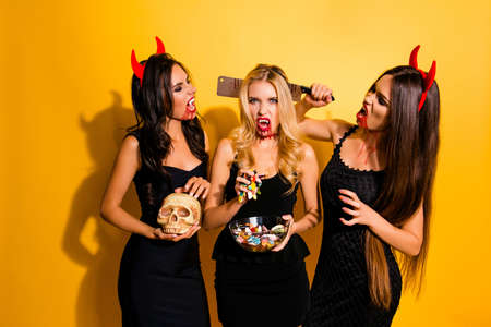 Terrifying gothic ladies with beaming white canines, cruel eyes, holding knife, gummy worms, braincaseの写真素材