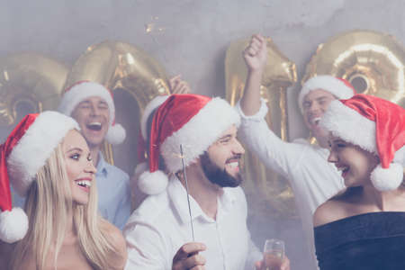 Closeup cropped of beautiful cute amazed festive crowd of youth, with bengal fires on luxury feast, in classy outfits, so glamorous and fancy! Relax disco mood, celebrating newyear all night long!の写真素材