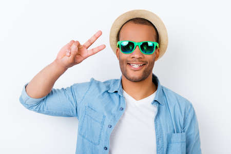 Peace! Funky young african male teen tourist is posing for vacation photo shot, wearing tourist`s...