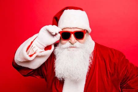 Cool funny playful naughty tourist santa grandfather, fooling around, holding his trendy specs, so...
