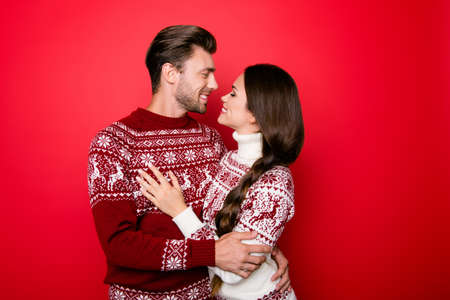 Portrait of adorable sweet family hugging and look into eyes of each other with such love and care, grin, in knitted cute traditional x mas wear with ornament, lady has braided  brunette hairの写真素材