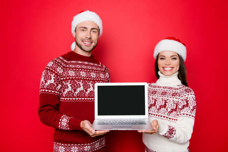 Discount, marketing, sales, advertisement, presents, gifts selling, copyspace concept. Holly jolly x mas, time! Cheerful married lovers hold modern device, beaming smiles, noel costumesの写真素材