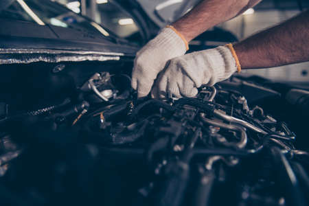 Close up cropped shot of experts appraisal of damage for repairing car at auto workshop, arms in...