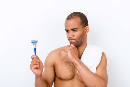 Skeptic, unsure, uncertain, doubts concept. Young african nude athletic guy is looking sceptical at...
