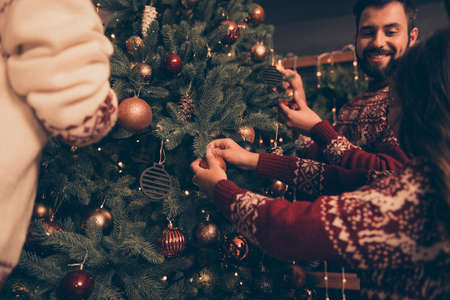 Closeup cropped shot of relatives at home in knitted traditional costumes, ready to celebrate x mas eve. Happiness, friendship, parenthood, childhood, upbringing, unity, mother, fatherの写真素材