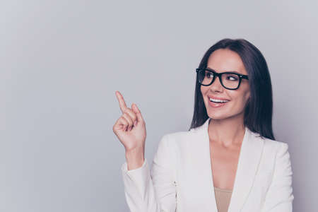 Welcome! Look! Successful gorgeous feminine intelligent stunning stylish leader expert in education, employment, pointing at empty space for advertising product or serviceの写真素材