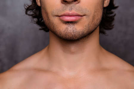 Close up cropped shot of nude hot guy`s bristle, chin, has perfect skin and hair, isolated on grey background. Barber shop, beard cut, shaving and styling conceptの写真素材