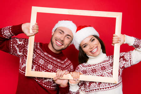 December x mas noel time! Adorable sweet caucasian couple bonding, so excited in knitted cute traditional x mas costumes with ornament, head wearの写真素材