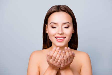 Attractive cute beautiful charming young woman with closed eyes and smile is going to wash her face...